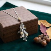 Naszyjnik Liść Dębu leży na drewnianej szkatułce