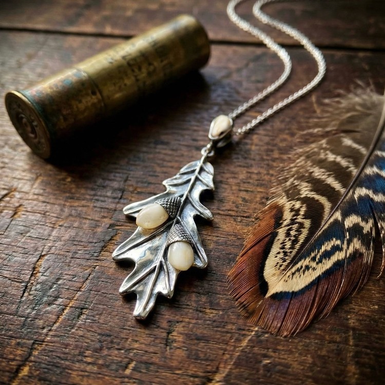 Naszyjnik myśliwski w kształcie liścia dębu na drewnianym stole