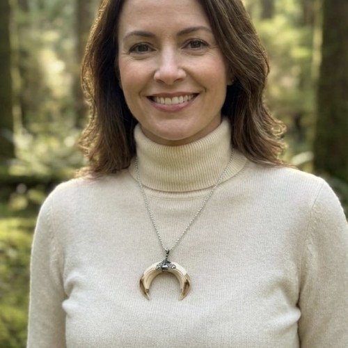 Hunting necklace with two wild boar tusks and oak ornament on a woman’s neck